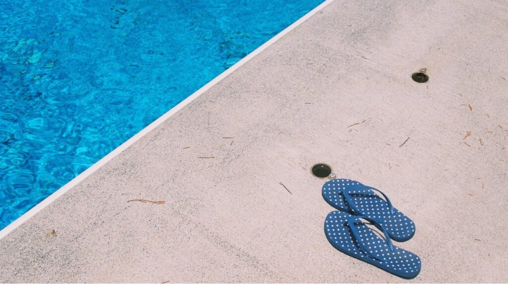 Blauwe slippers aan het zwembad